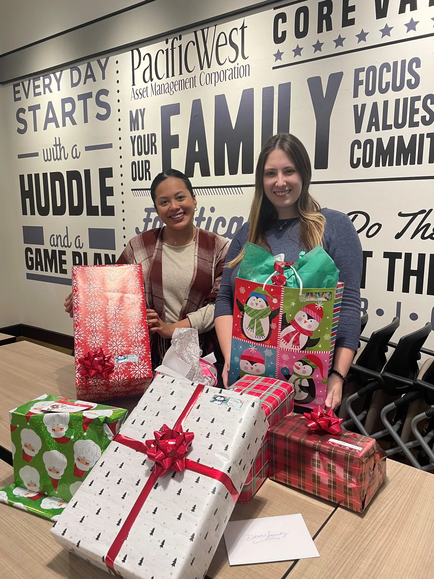 PacificWest colleagues collecting wrapped gifts at the office